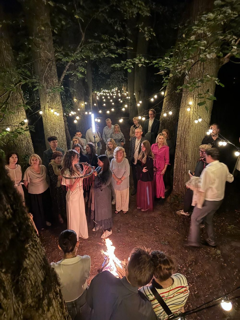 Evening ceremony by firelight in the manor's alley of trees